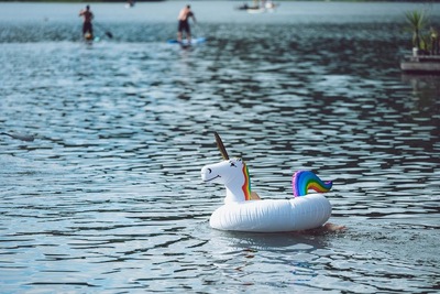 A person floating on a body of water with a unicorn float